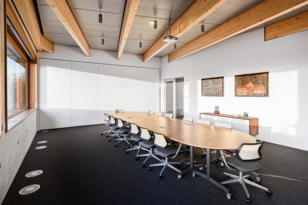 Meeting room with a long table and framed artworks at TRUMPF Hungary in Gödöllő