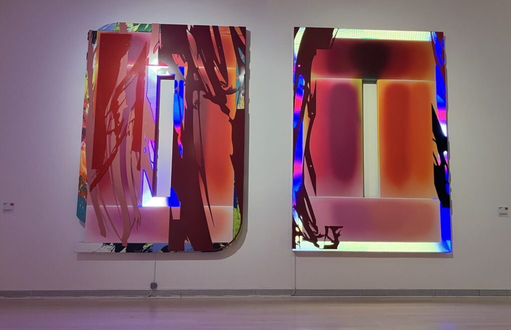 Two large colourful metal panels by Márton Nemes on a gallery wall