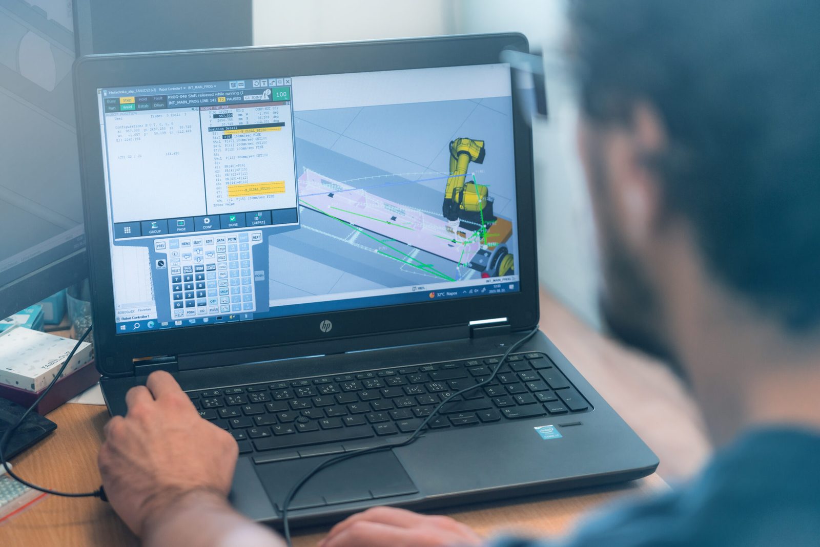 Programming an industrial robot in simulation software on a laptop