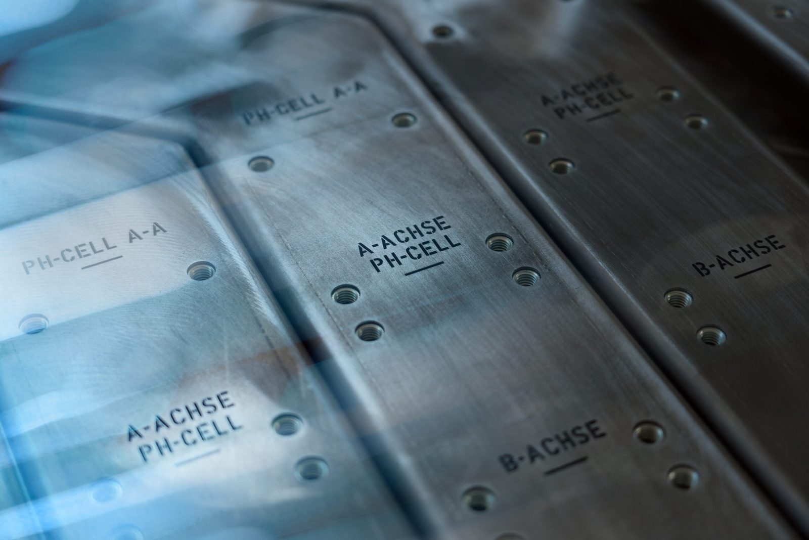 Engraved sheet metal parts marked A-ACHSE, B-ACHSE and PH-CELL